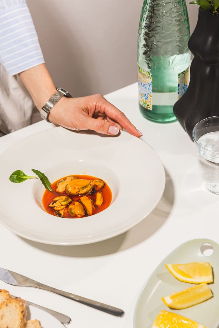 Chef placing a plated dish on the table