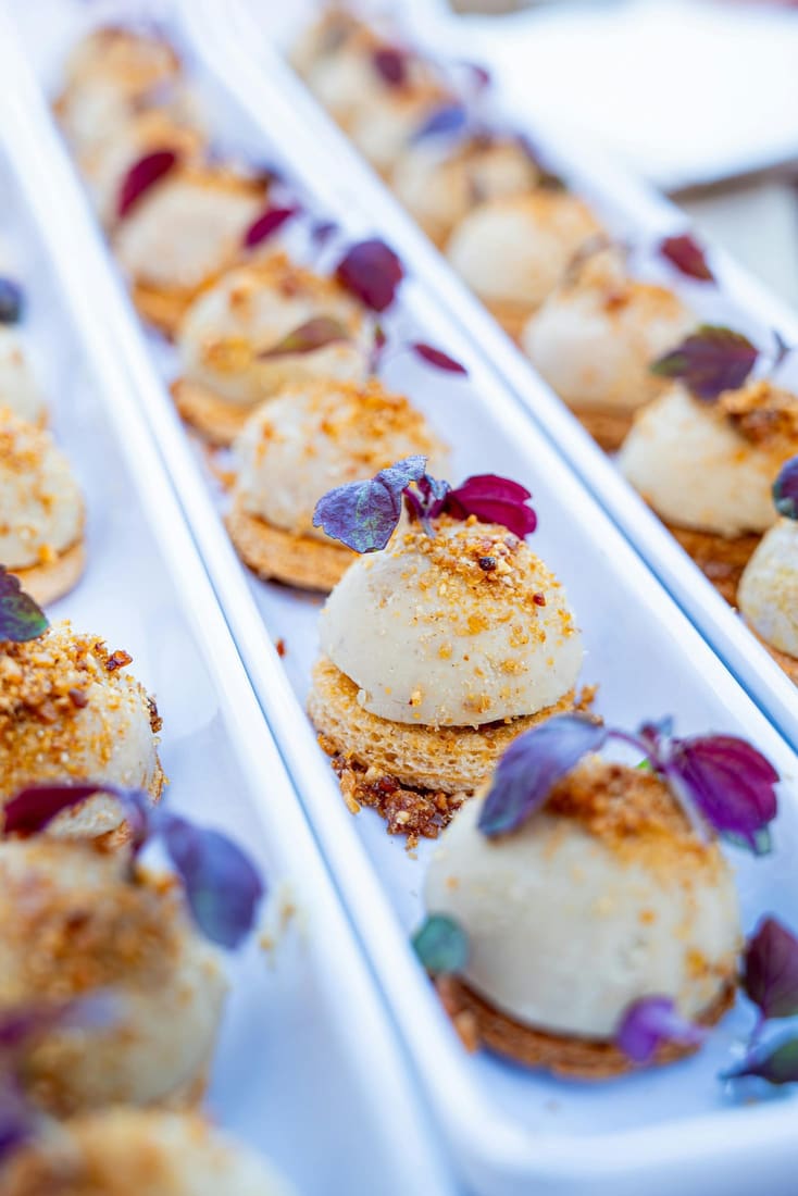 Canapés plated in a row, garnished with edible petals